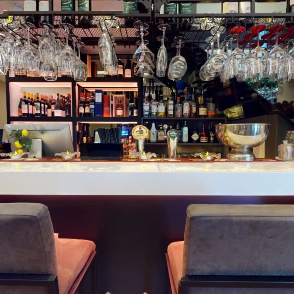 Wine bottles and hanging glasses above the bar