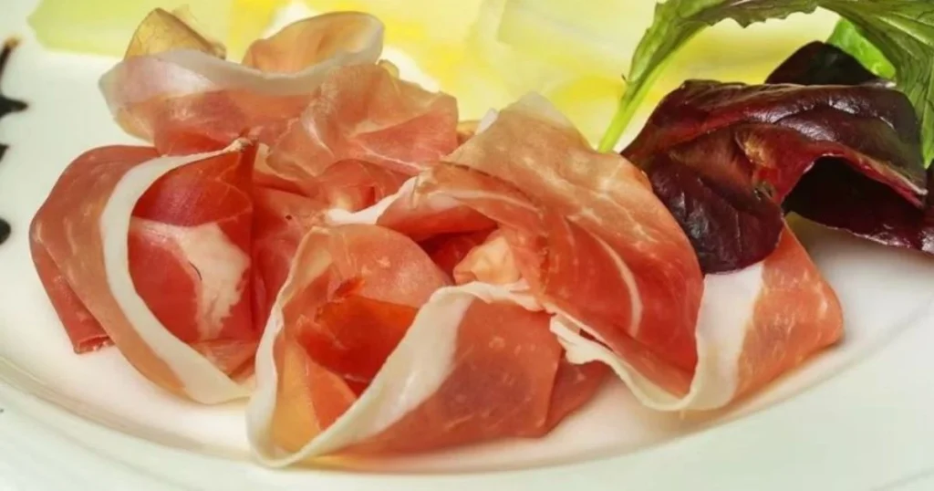 Traditional Italian prosciutto antipasto served with fresh salad garnish
