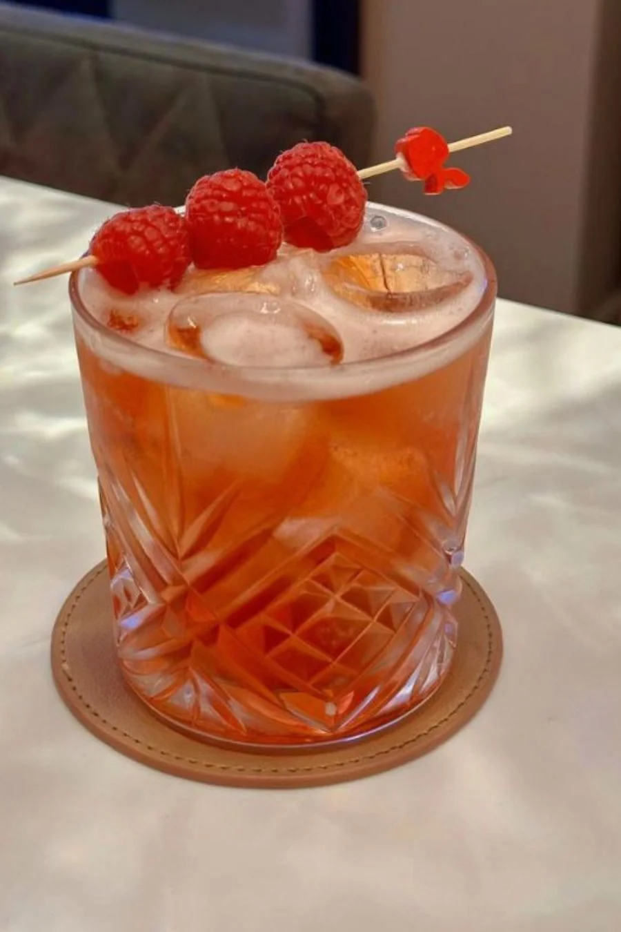 Cocktail with raspberries served over ice