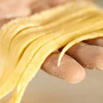 Fresh homemade pasta being prepared by hand