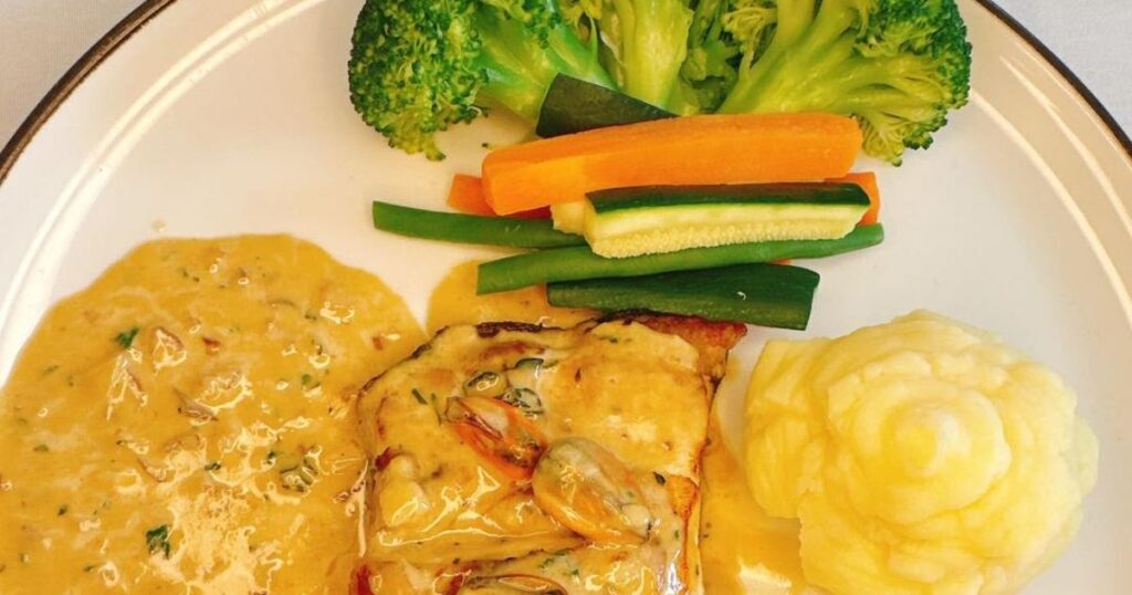 Chicken served with mashed potato, vegetables and creamy sauce