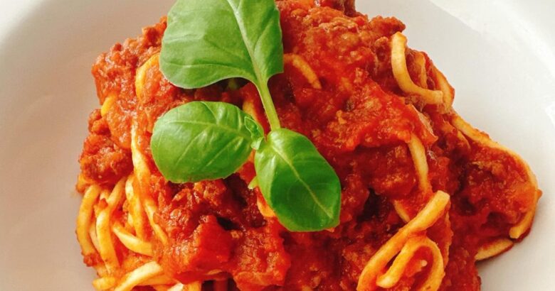 Spaghetti Bolognese with rich tomato and meat sauce topped with fresh basil
